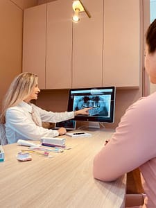 Dentista especialista em tratamento de canal explicando radiografia odontológica durante consulta em Balneário Camboriú